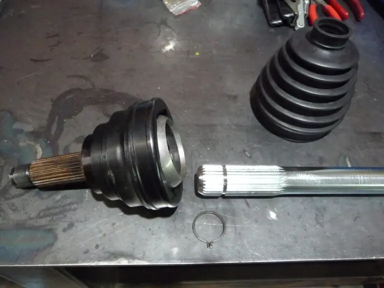 Car CV joint disassembled on workbench.
